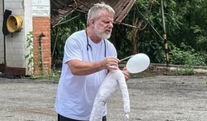 O ator Oswaldo Moraes se apresenta no páteo da Usina eco-cultural segurando um boneco branco de tecido com a cabeça feita de balão de borracha